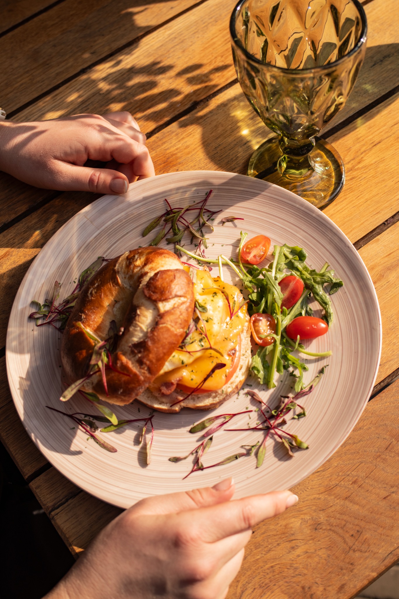 A plated brunch dish with a filled bagel and salad