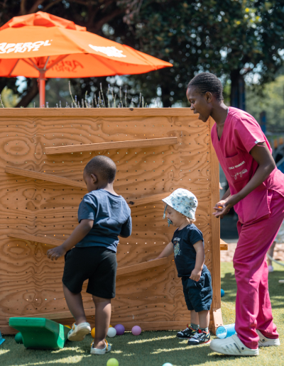 Children playing with a JoyJozi team member during an outdoor activity