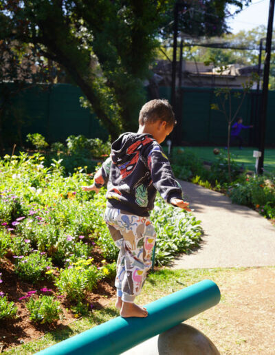 A child exploring the outdoor play garden at JoyJozi