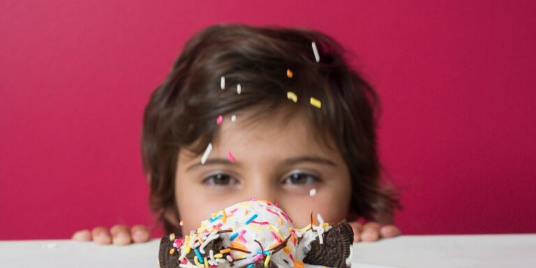 Child with a colourful sprinkle-covered treat at JoyJozi birthday celebration